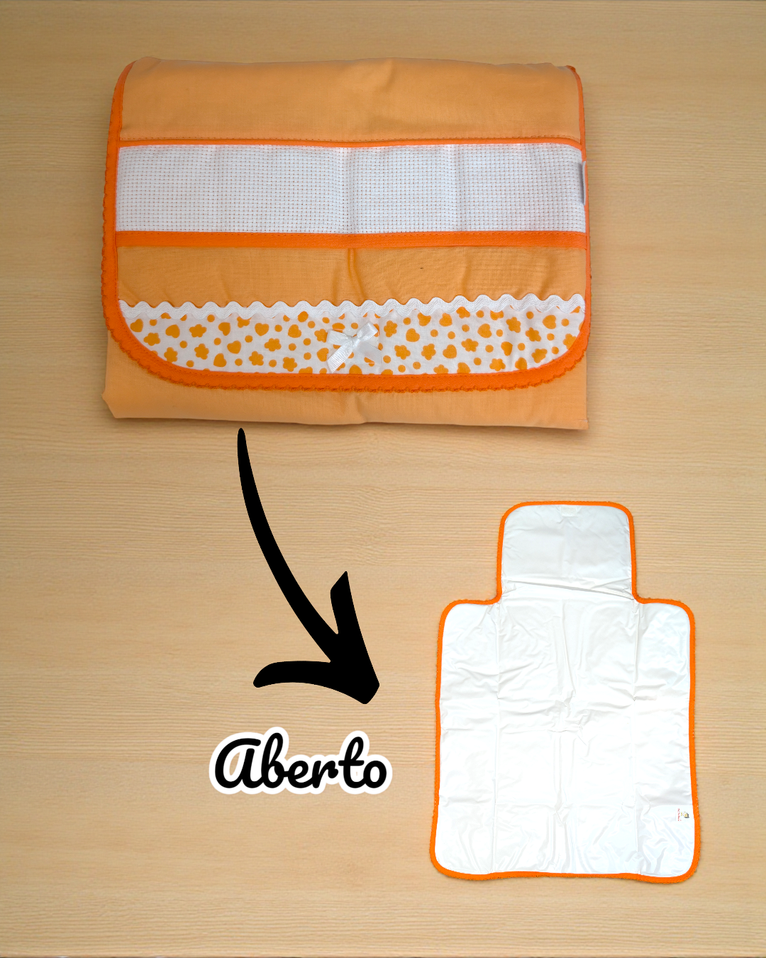 Muda-fraldas portátil laranja fechado e aberto sobre fundo de madeira