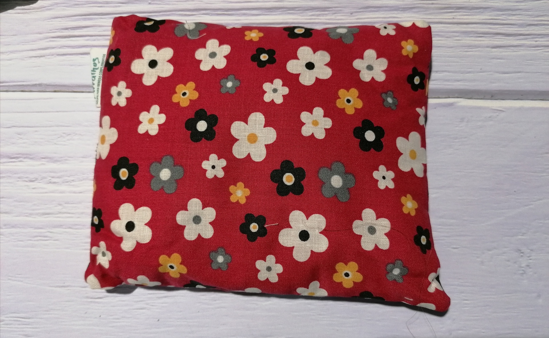 Almofada pequena vermelha com padrão de flores diversas