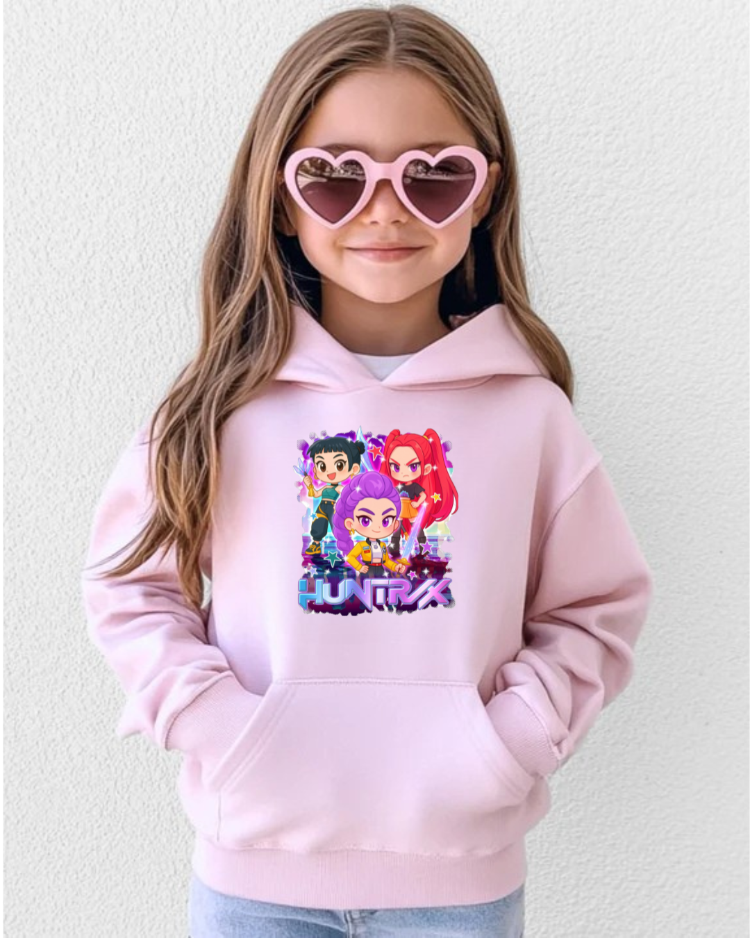 Criança com hoodie rosa claro com estampa animada e óculos de sol rosa em forma de coração.