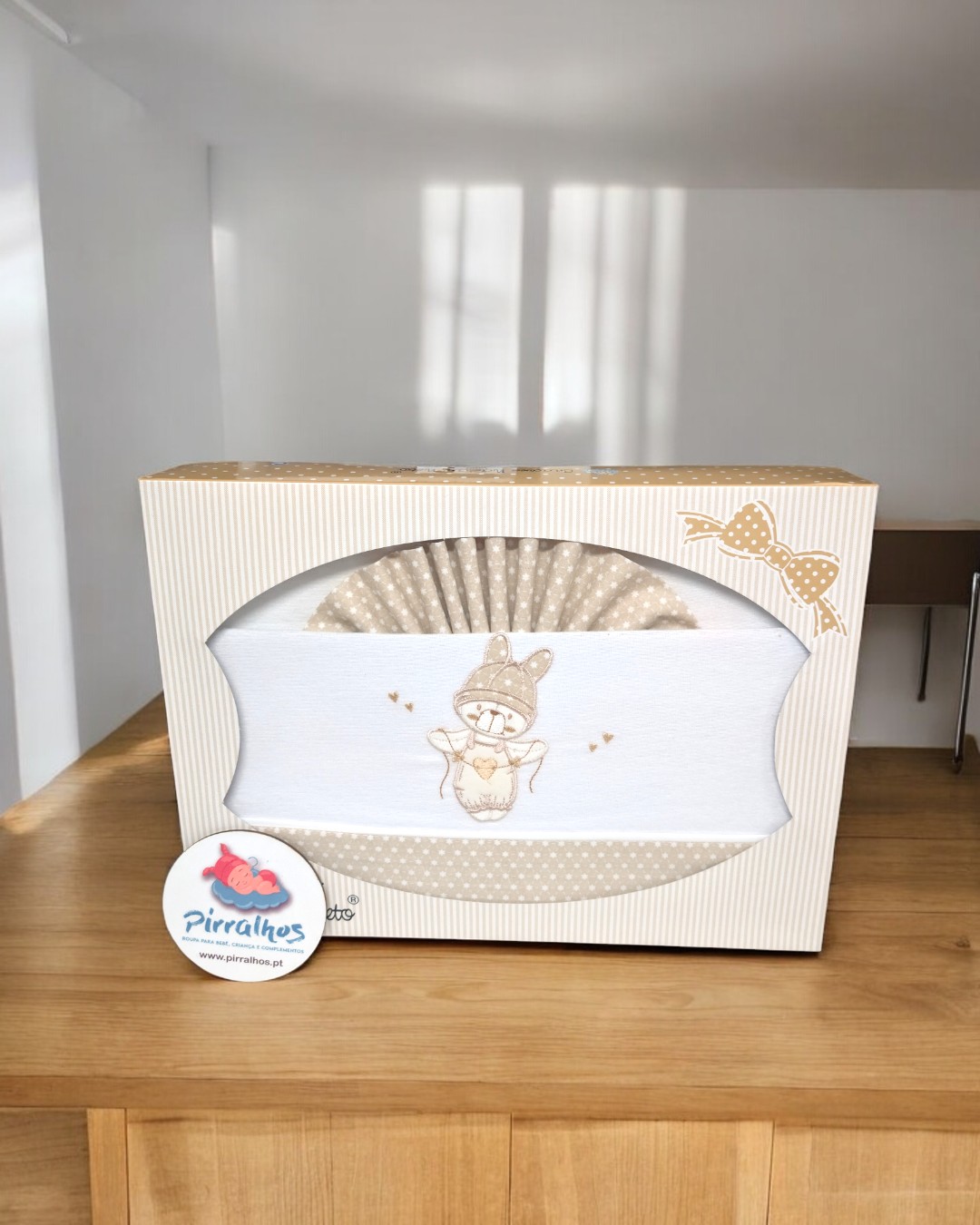 Conjunto de bebé com ursinho bordado em caixa decorativa bege e branca.