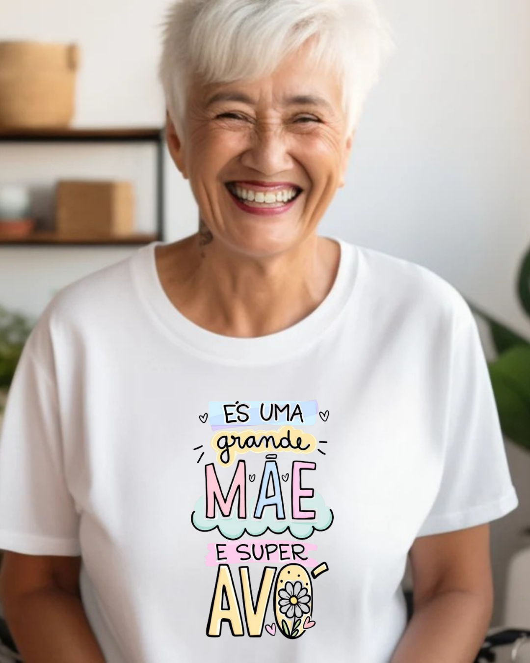 Mulher sorridente com t-shirt branca e texto colorido sobre mãe e avó
