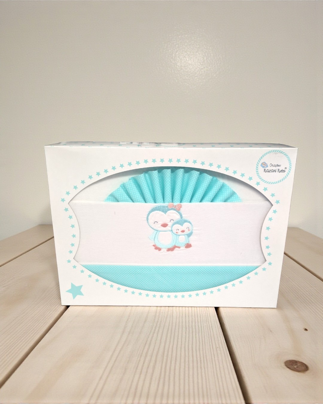 Caixa branca com estrelas azuis com têxteis de pinguins bordados