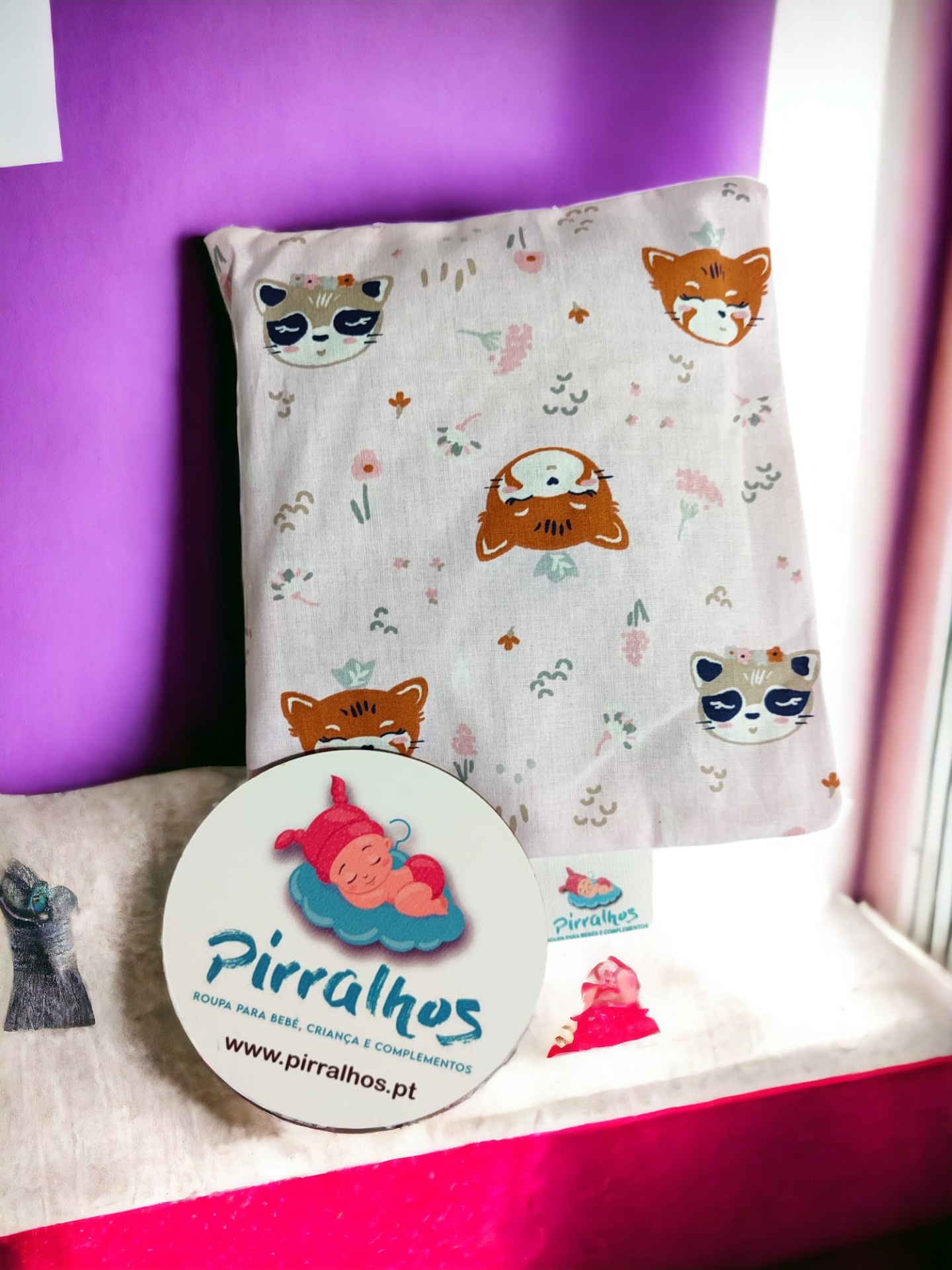 tecido com estampado de animais e placa com logotipo e texto