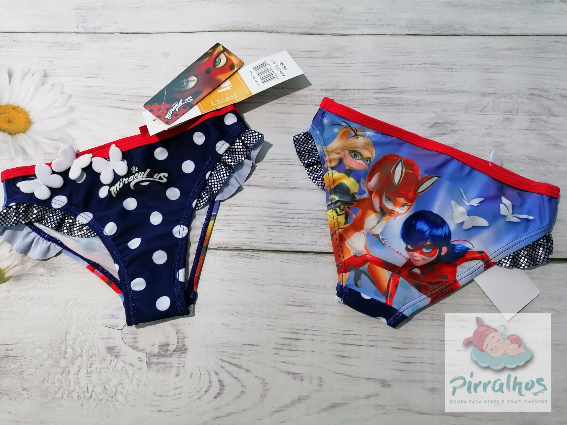 Cuecas de criança azul com bolinhas e colorida com personagens em fundo de madeira clara