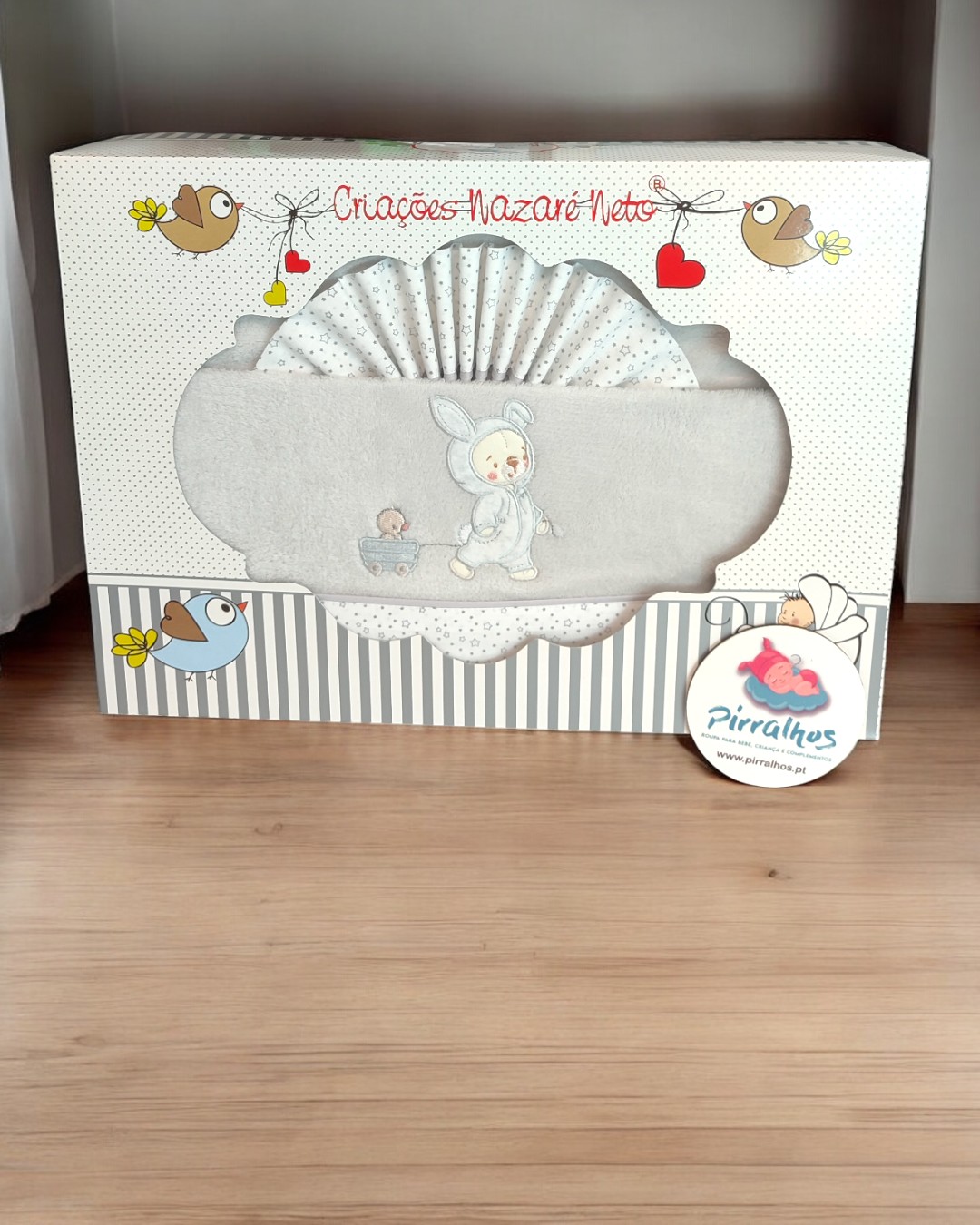 Conjunto de têxteis para bebé cinza com bordado de criança e pato em caixa decorada.