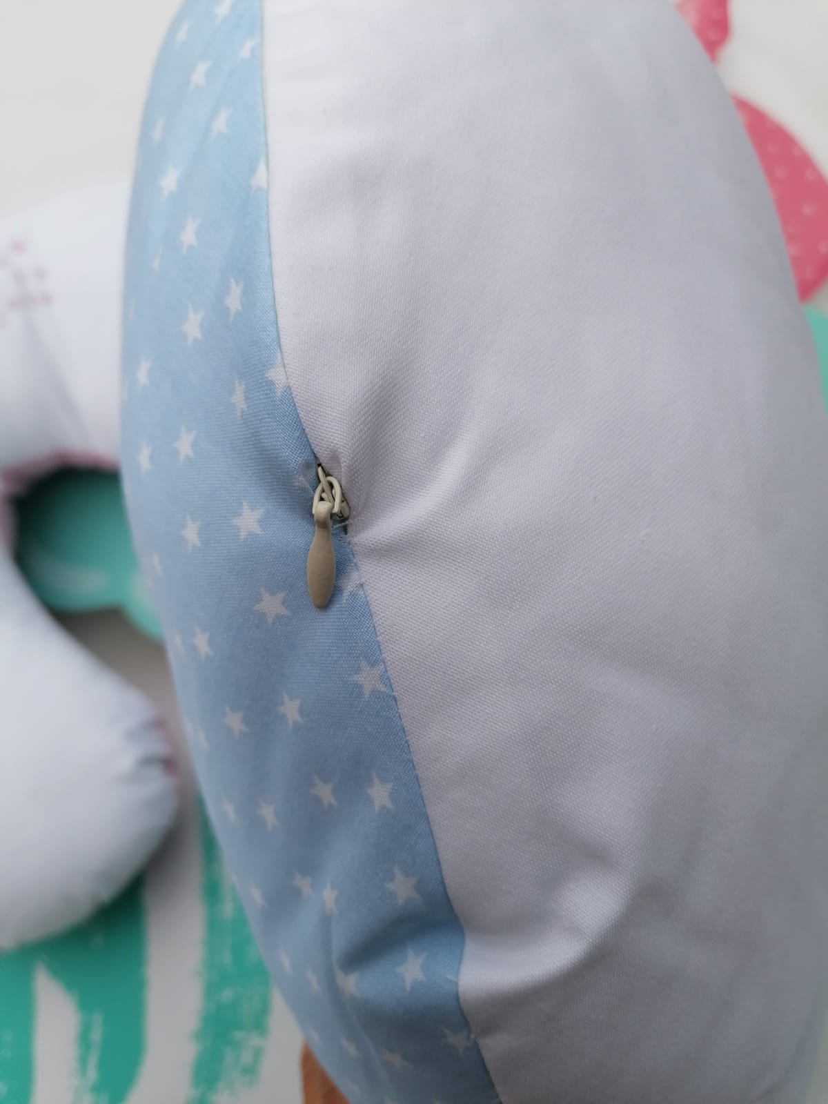 Almofada azul com estrelas brancas e branca com zíper