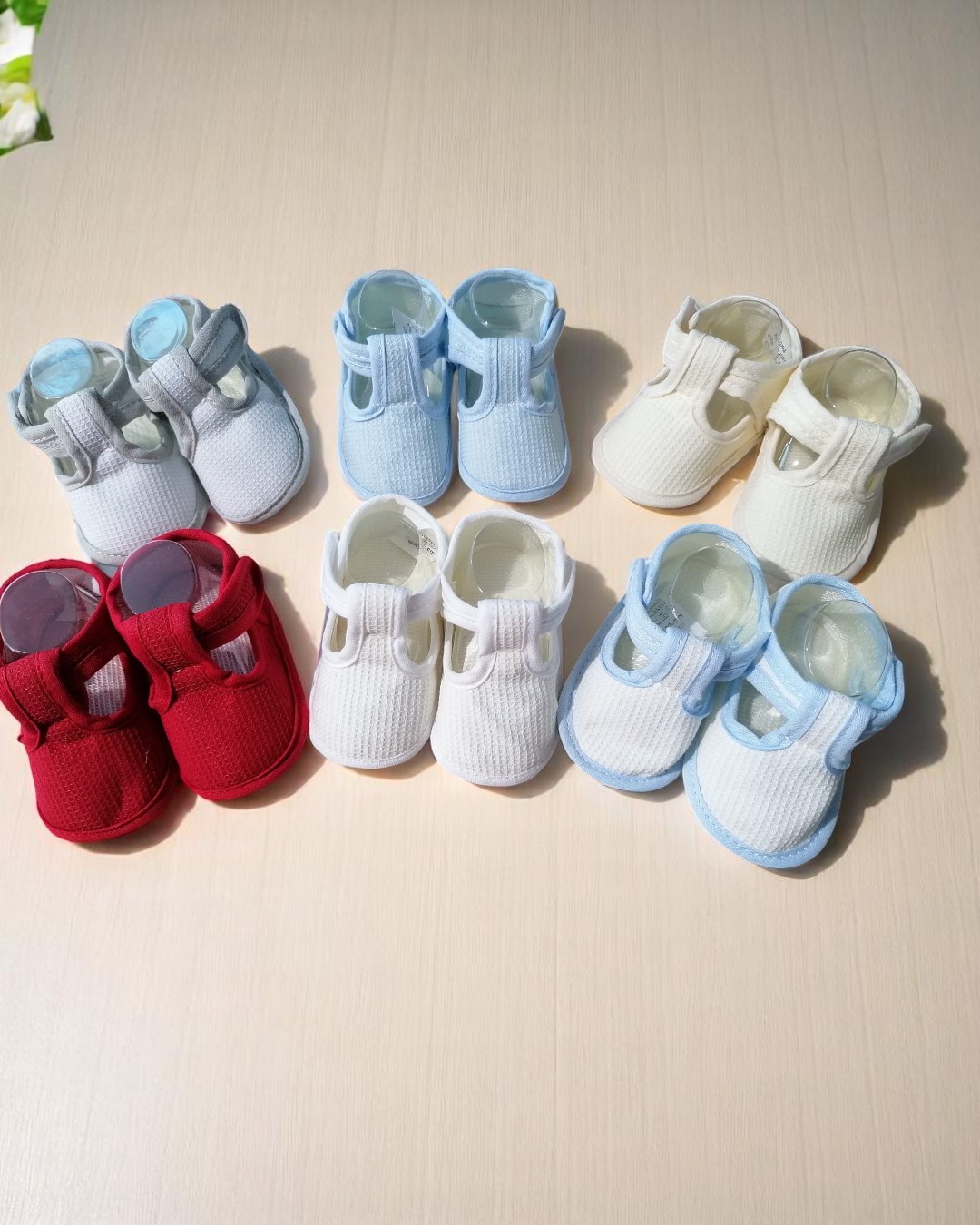 Set de sapatinhos de bebé multicolor feitos de tecido com fecho velcro.