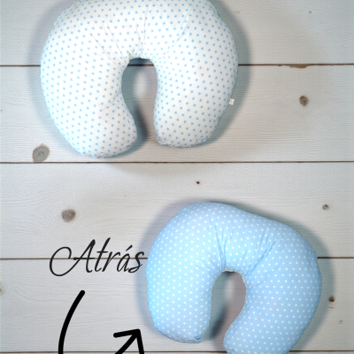 Dois almofadas U para pescoço, branco com estrelas azuis e azul com estrelas brancas, em fundo de madeira clara com texto Atrás e seta.
