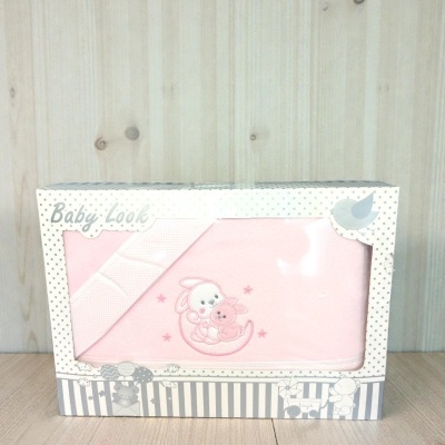 Manta rosa para bebé com bordado de coelhinhos numa caixa decorada