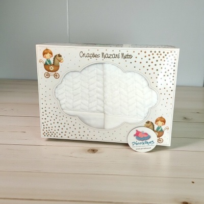 Embalagem com produto têxtil branco com padrão e detalhes dourados