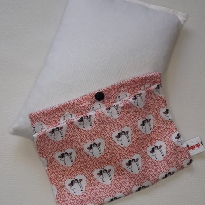 Almofada branca e saco de tecido cor-de-rosa com padrão de mulheres desenhadas e botão preto