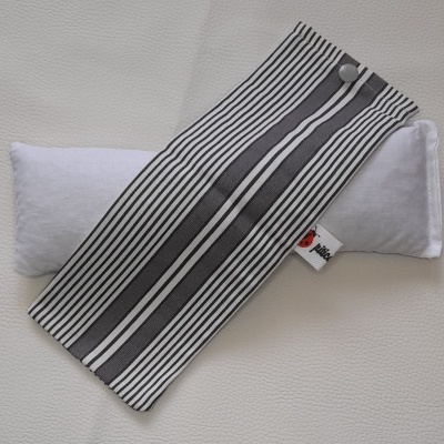 Estojo com riscas pretas e brancas sobre almofada branca