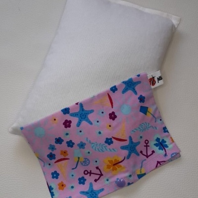 Almofada branca com capa rosa decorada com motivos marítimos coloridos