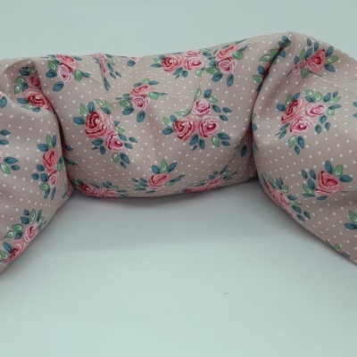 Almofada rosa com padrão de flores e bolinhas brancas