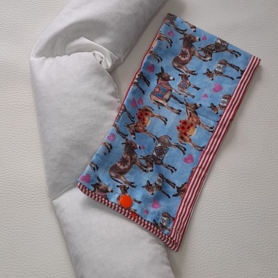 almofada branca com pano azul de cavalos