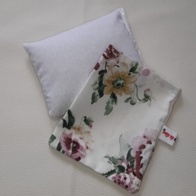 Almofada branca pequena com capa floral removível e botão de pressão