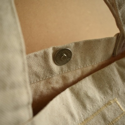Bolsa bege de tecido com fecho de pressão metálico