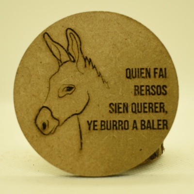 Produto redondo em cortiça com desenho de burro e texto em espanhol