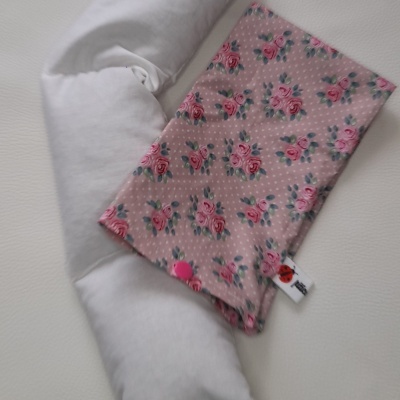 Travesseiro branco com bolsa rosa florida em superfície branca