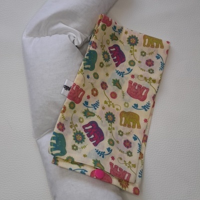 Almofada branca comprida com almofada estampada de elefantes e flores coloridas