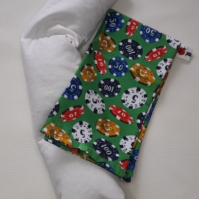 Almofada branca longa com capa verde estampada com fichas de poker coloridas