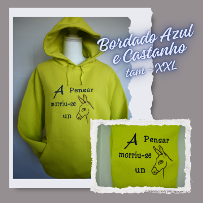 Casaco amarelo com capuz e bordado azul e castanho com imagem de burro e texto em português.
