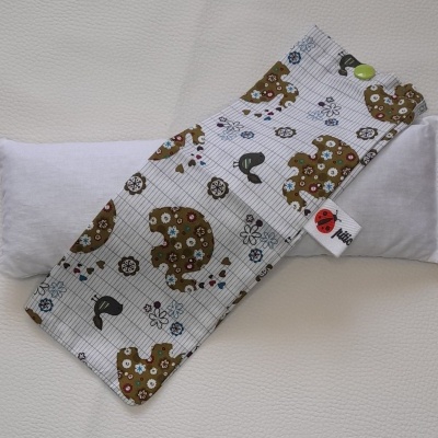 Protector de tecido com estampa de ursos castanhos e flores sobre almofada branca