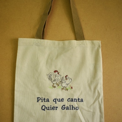 Sacola bege com desenho de galinhas e texto bordado azul