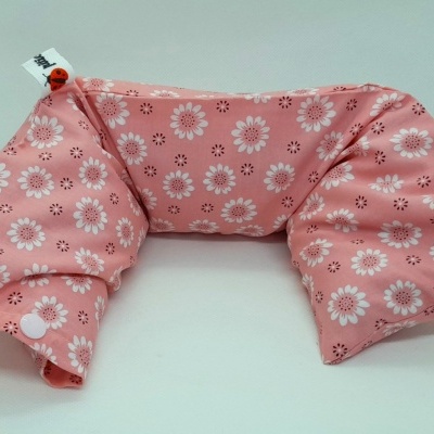 Almofada rosa com flores brancas e etiqueta.