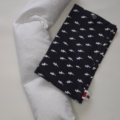 Travesseiro branco com faixa de tecido preta estampada com raios brancos