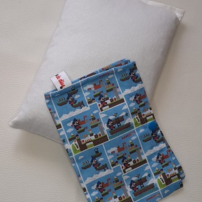 Almofada branca e fronha azul com padrão de desenho animado