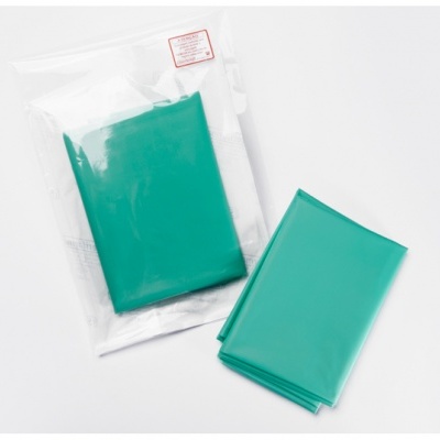 Capa ou saco plástico verde, embalado e aberto, sobre fundo branco