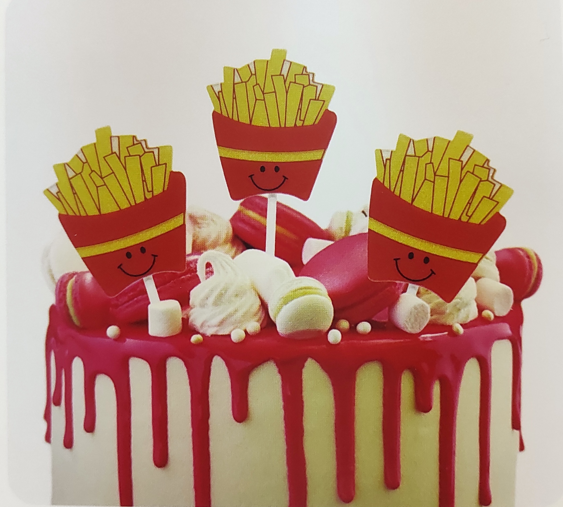 Bolo branco com cobertura rosa e toppers de batatas fritas sorridentes em palitos