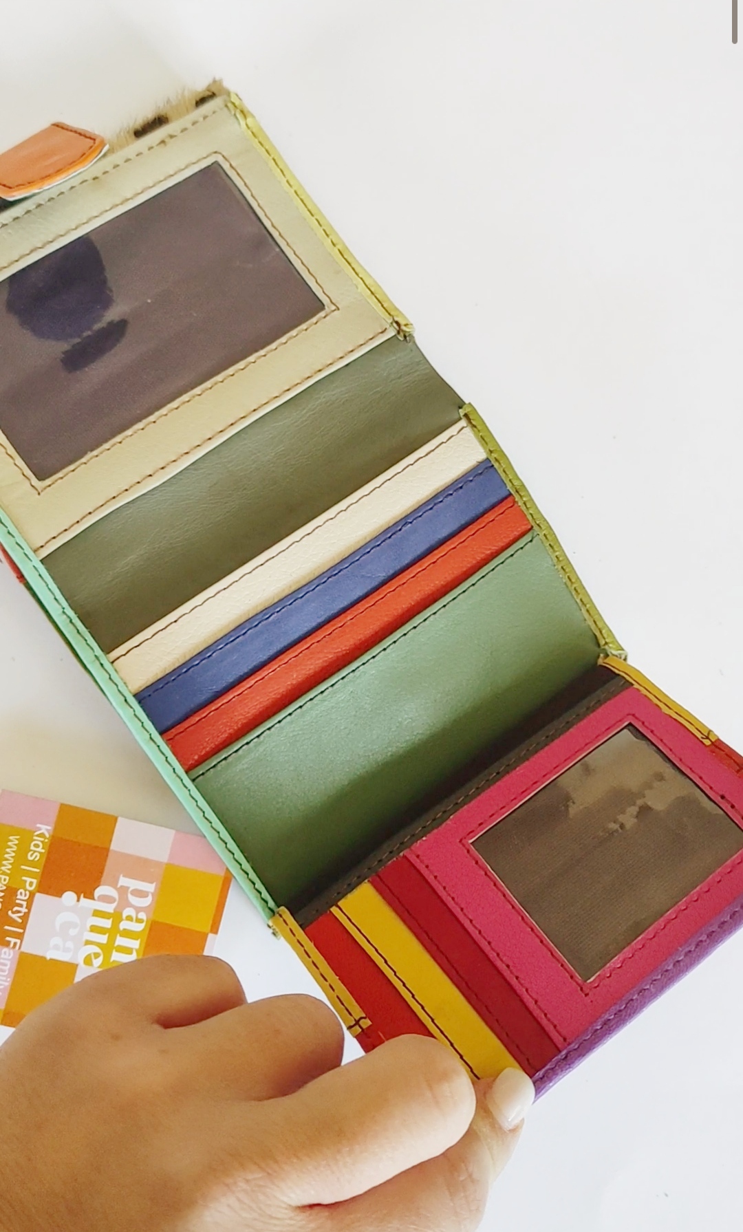 Carteira de couro colorida com vários compartimentos e janelas transparentes