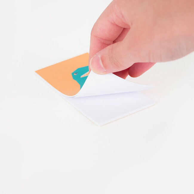 Mão a levantar a página superior de um bloco de notas com imagem colorida.