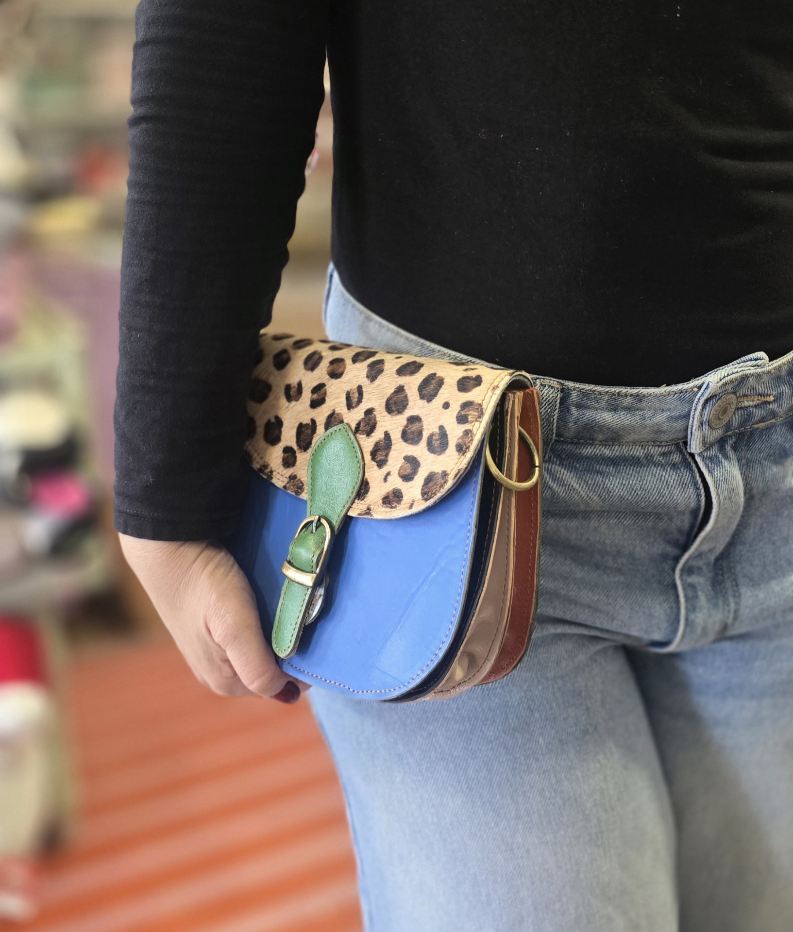 mala pequena com padrão animal e corpo azul usada na cintura