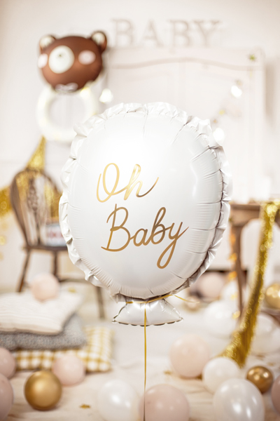 Balão branco oval com texto dourado Oh Baby e decoração festiva com balões e cadeiras