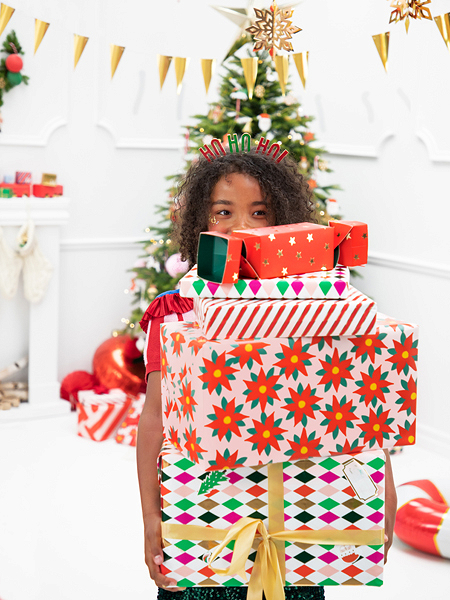 Criança com presentes coloridos em ambiente natalício