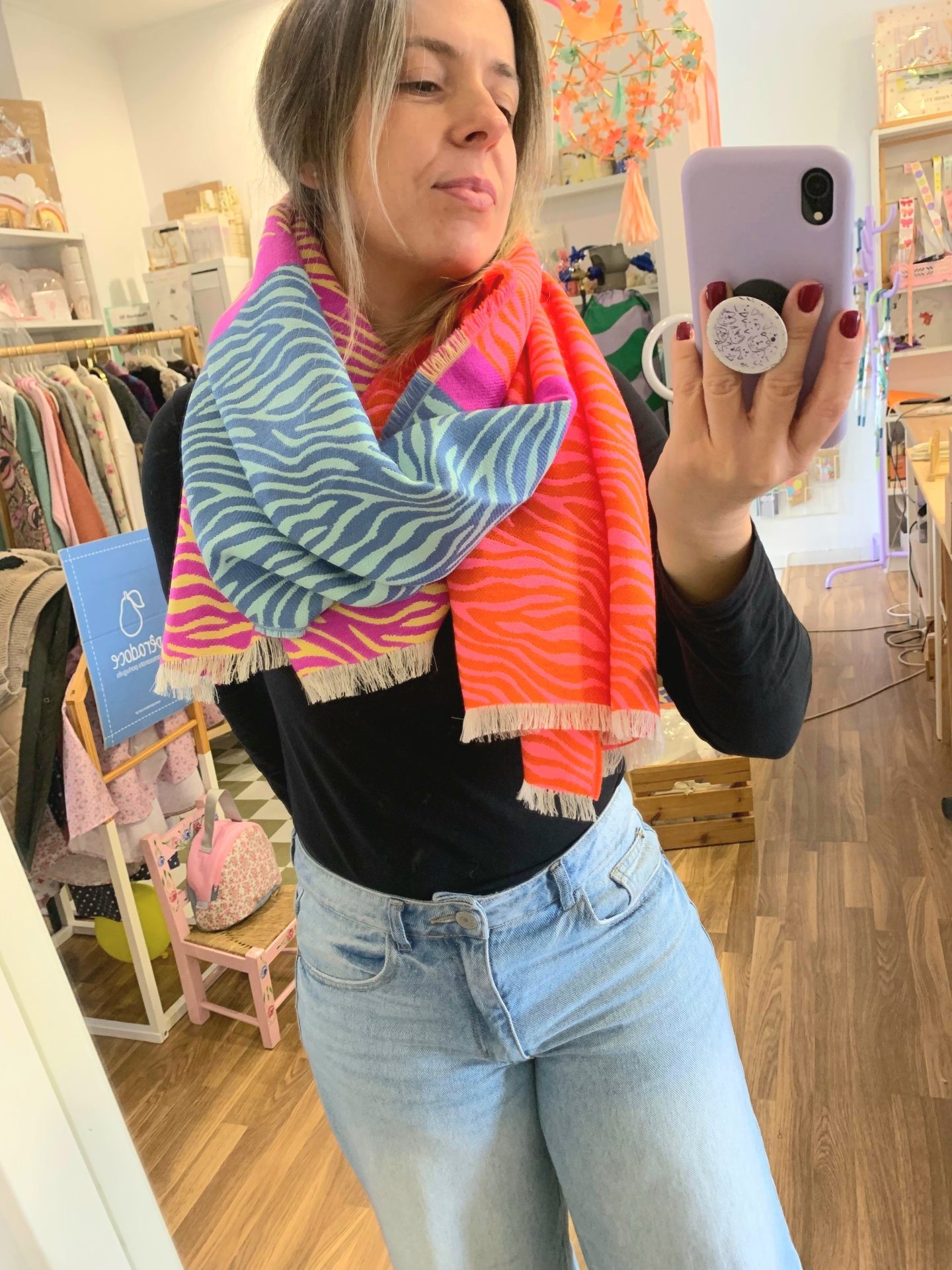 Lenço colorido com padrão zebra usado por mulher num ambiente de loja