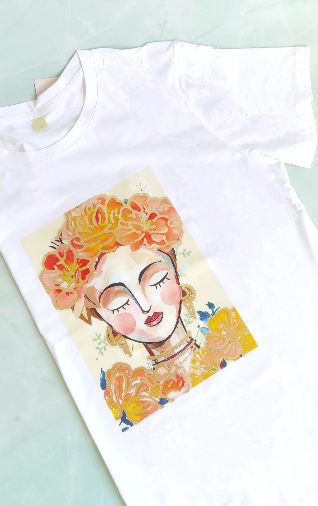 T-shirt branca com estampa de rosto feminino e flores coloridas