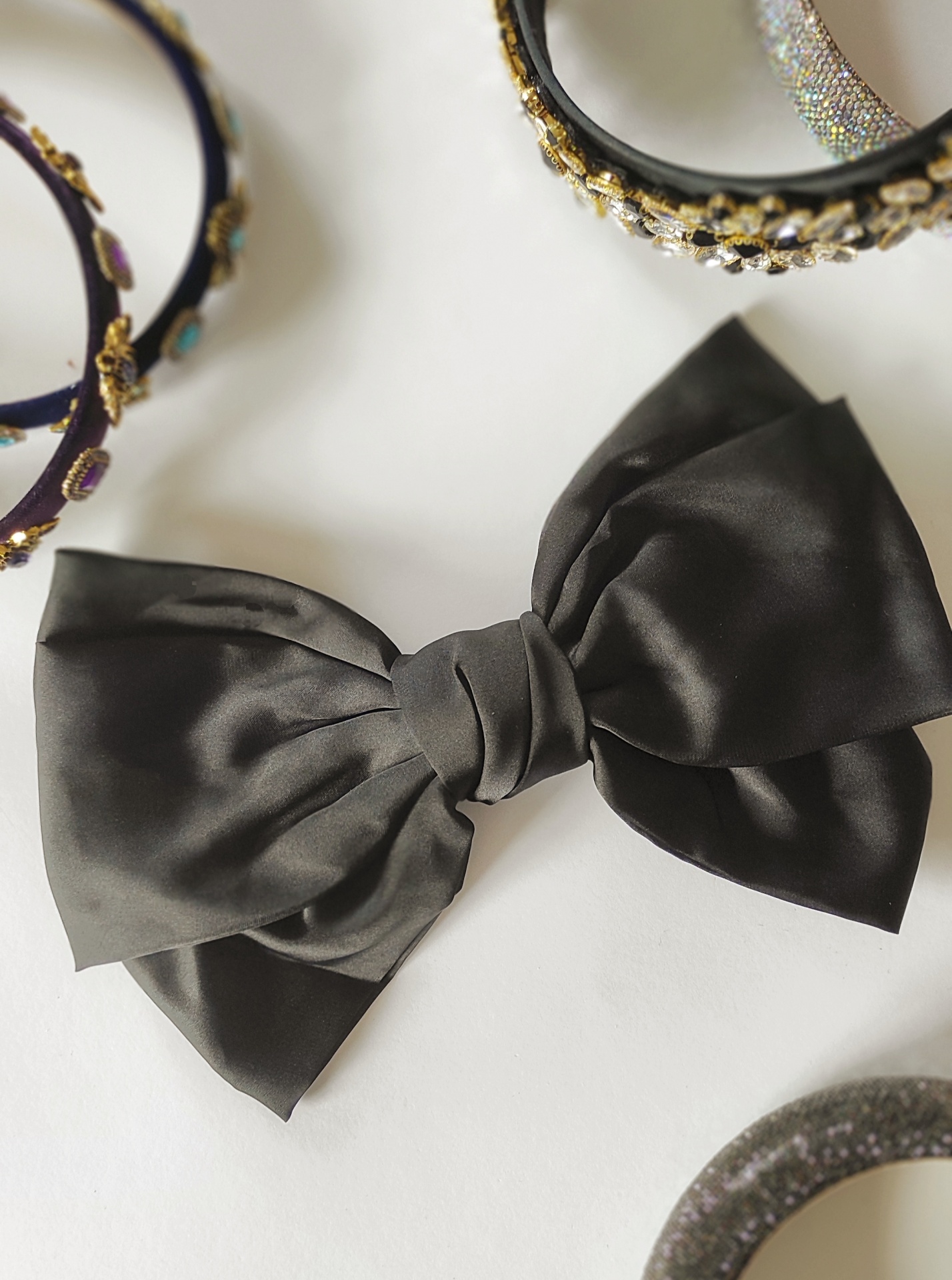 Laço preto acetinado e tiaras decorativas em fundo branco