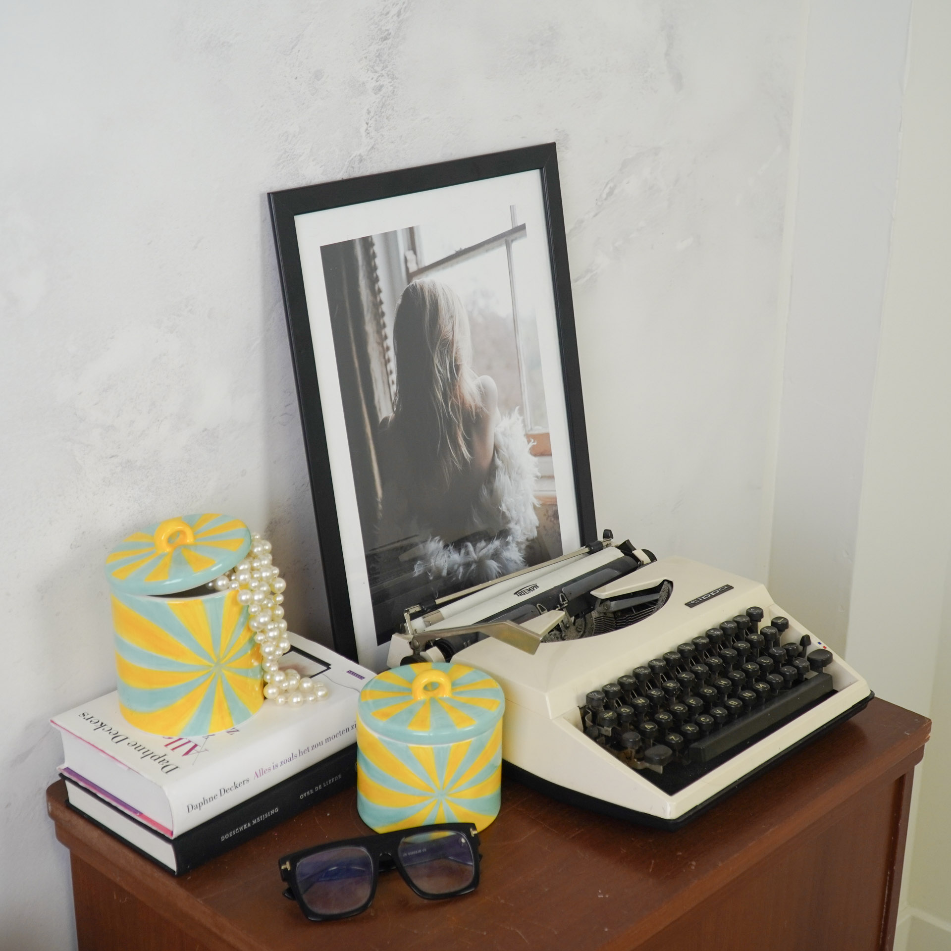 Secretária com máquina de escrever branca e objetos decorativos