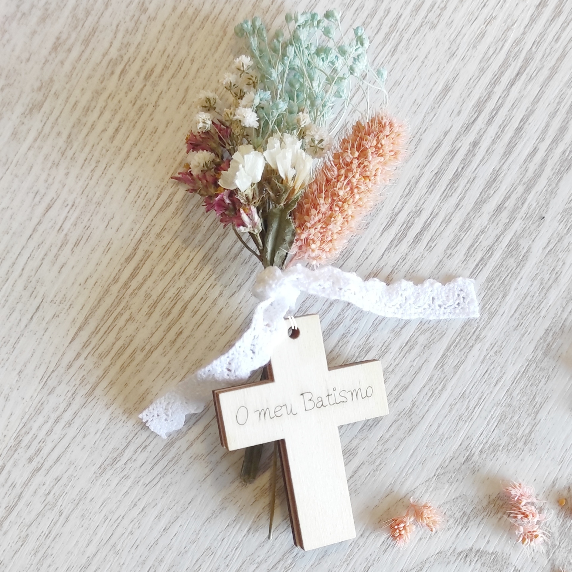 arranjo de flores secas com cruz de madeira e fita de renda branca