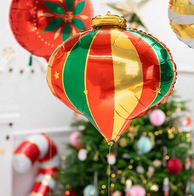 Balão foil colorido em formato de lanterna chinesa com árvore de Natal ao fundo