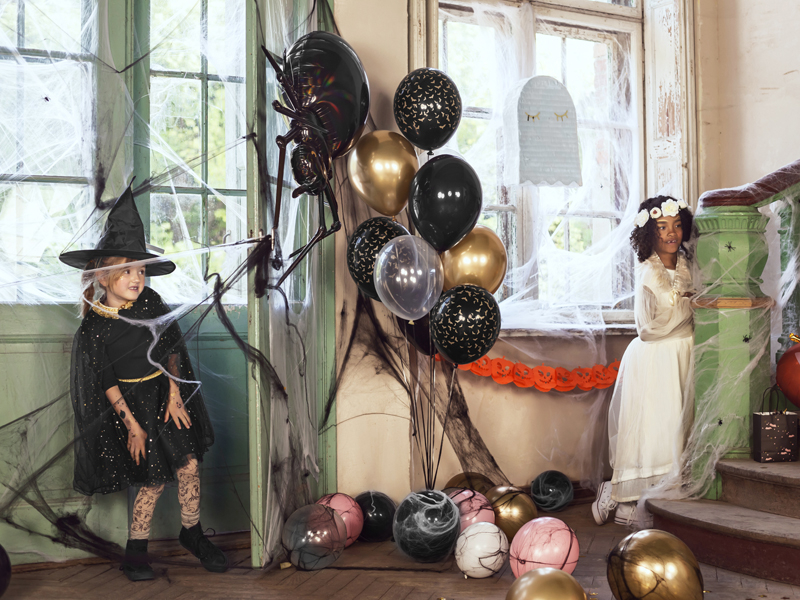 Duas crianças em fantasia de Halloween com decorações de balões e teias de aranha