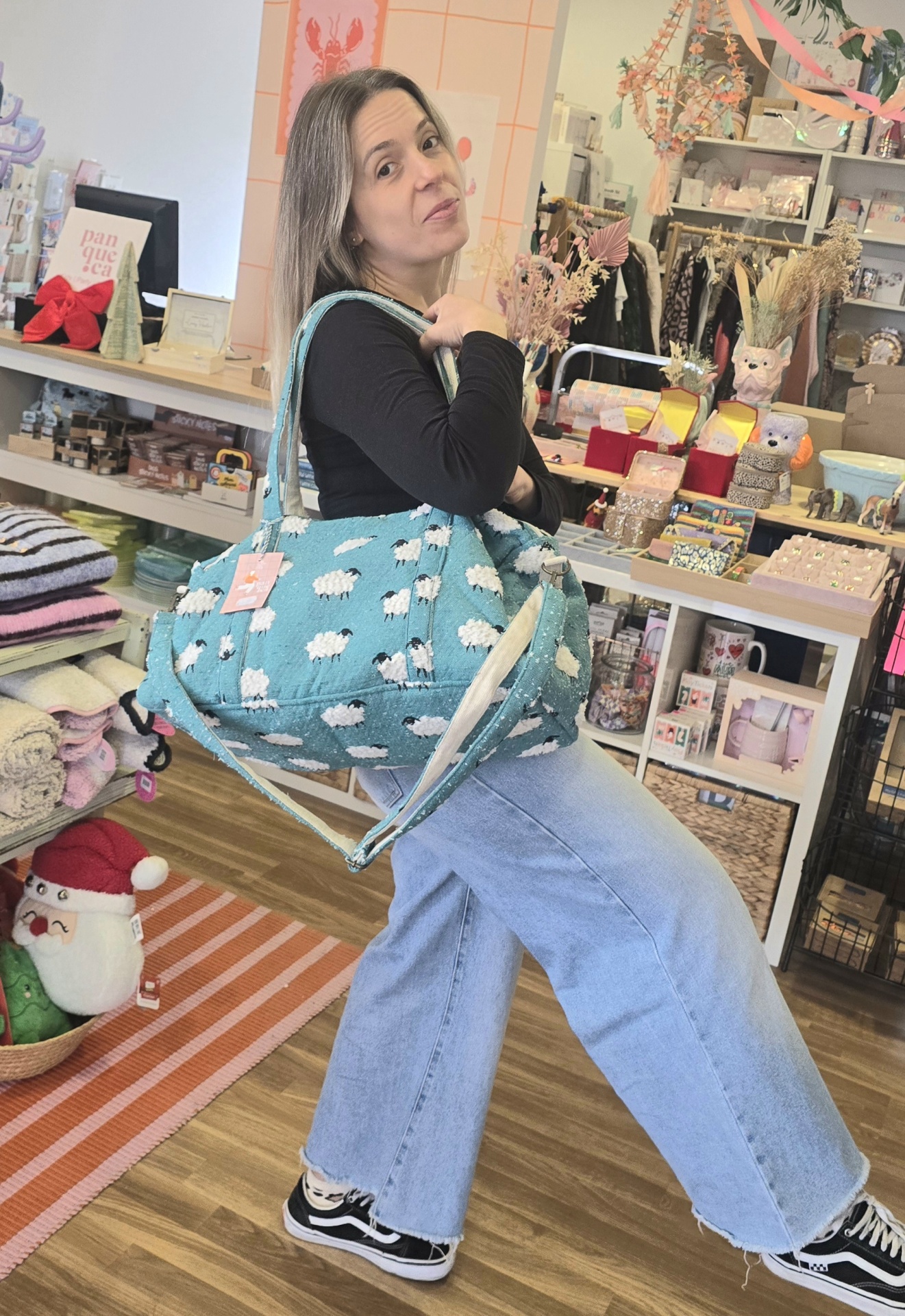 Mala azul com padrão de ovelhas em ambiente de loja colorida