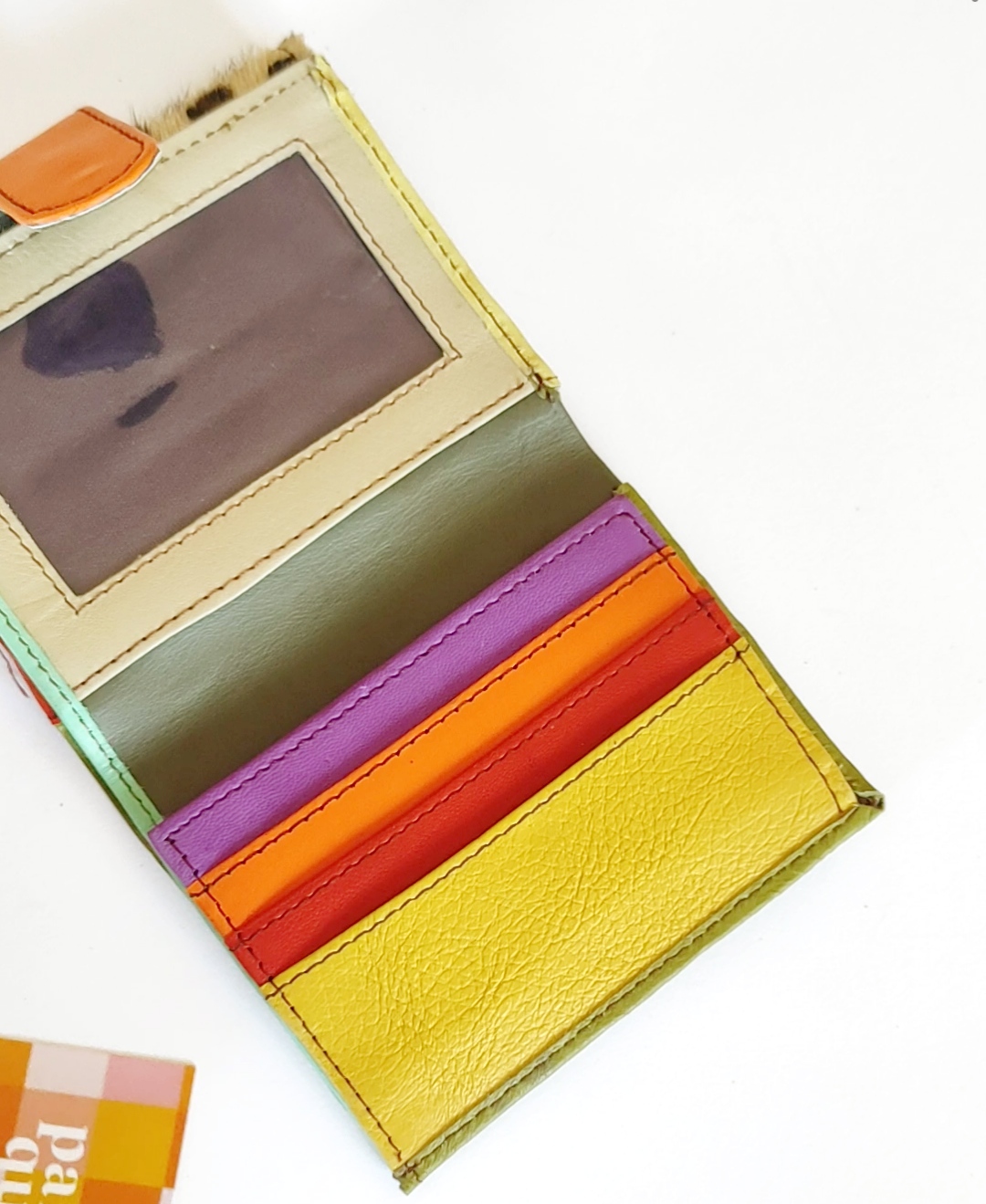 Carteira colorida de couro com múltiplos compartimentos abertos