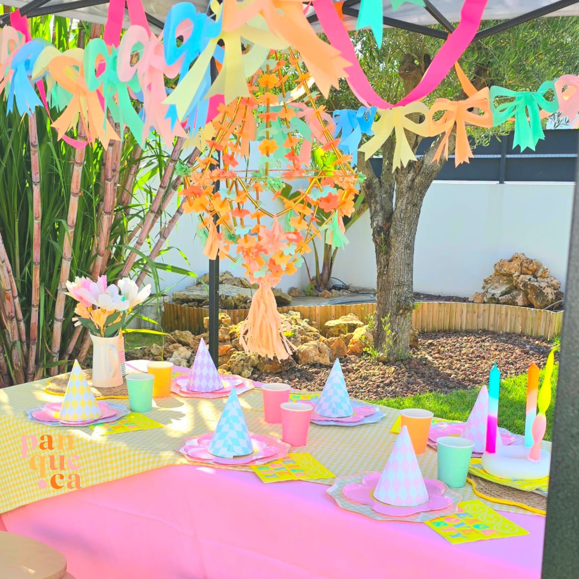 Mesa decorada para festa infantil com elementos coloridos ao ar livre