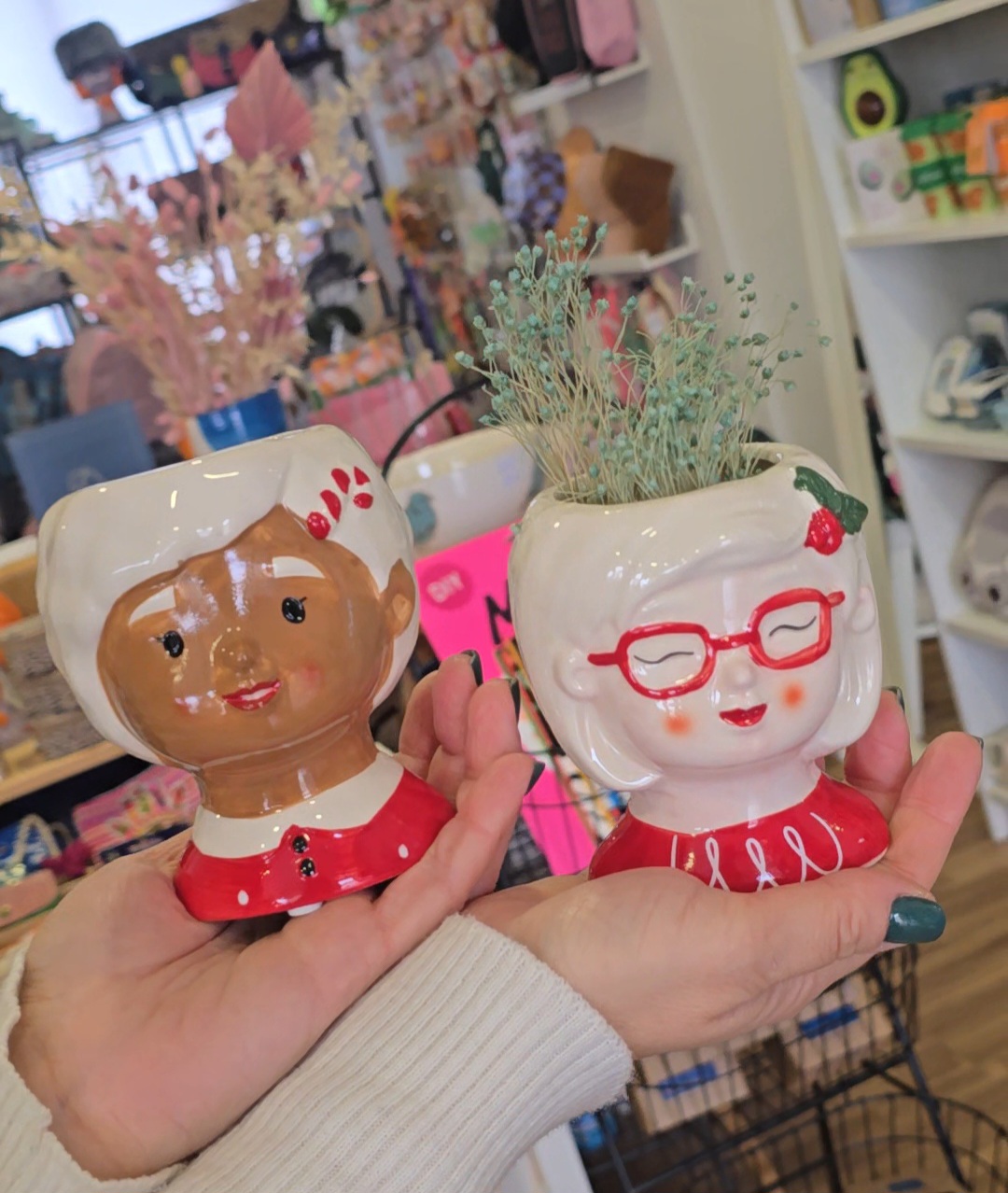 Vasos cerâmicos decorativos com rostos femininos e plantas secas