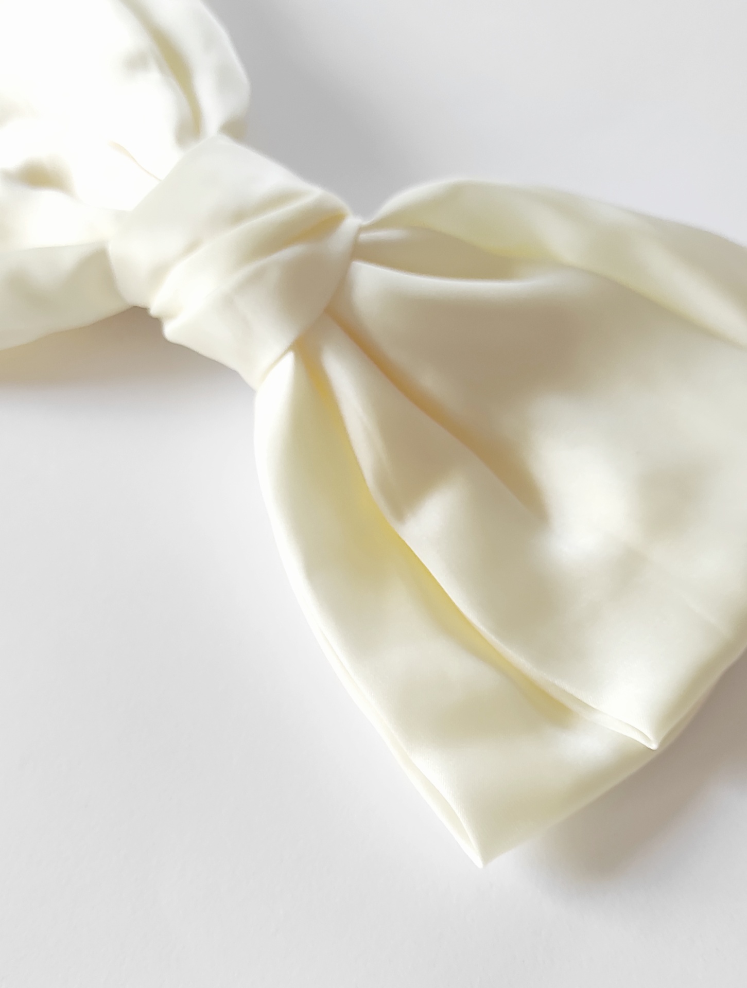 Laço branco em tecido acetinado com brilho suave